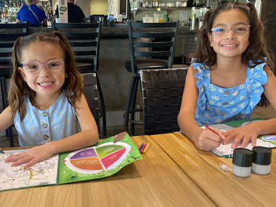 Two girls in glasses, coloring