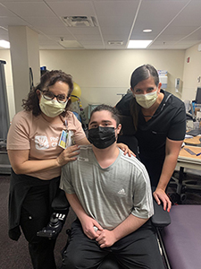 Nurses standing next to patient in wheelchair