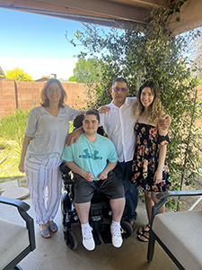 Family of 4 posing on back patio