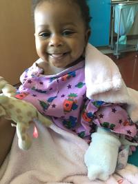 Toddler in purple hospital gown