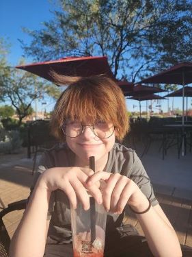 Teen wearing glasses, smiling at camera