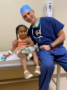 Provider in scrubs next to young patient