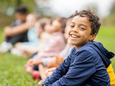 Boy in blue hoodie, smiling at camera