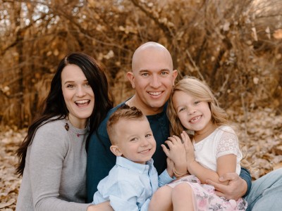 Family of 4 posing in the leaves