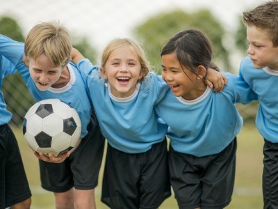 5 young soccer players laughing