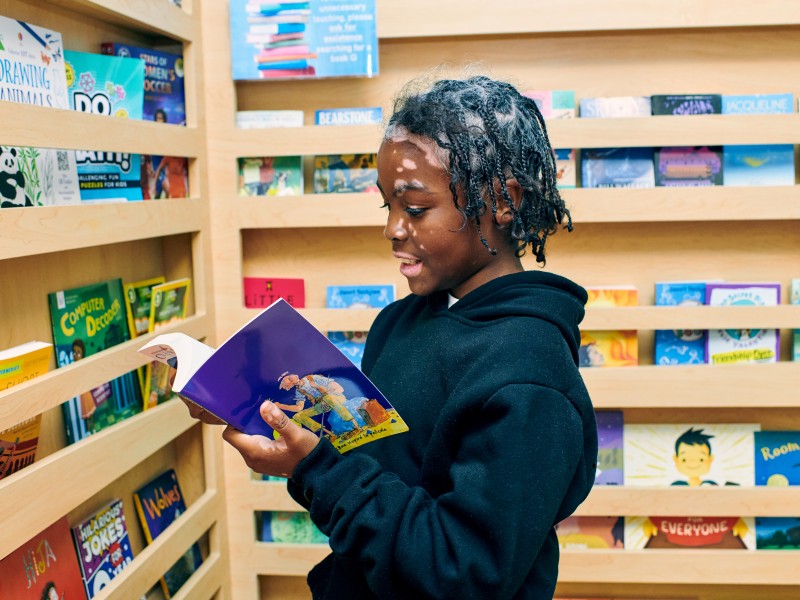 Young boy reading a book in a playroom