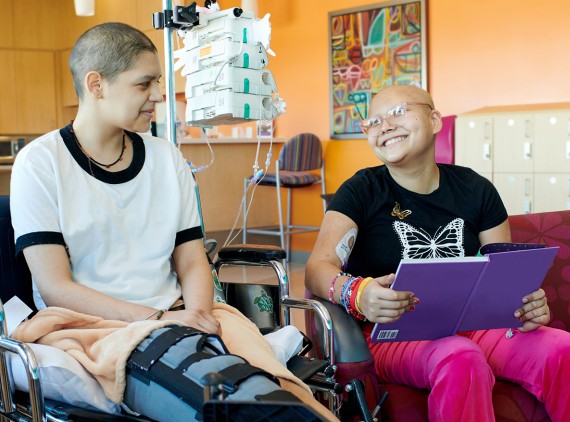 Two girls smiling while talking about a book
