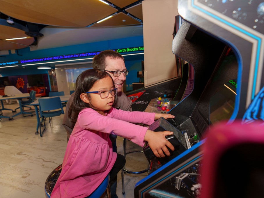 Girl and parent playing arcade game